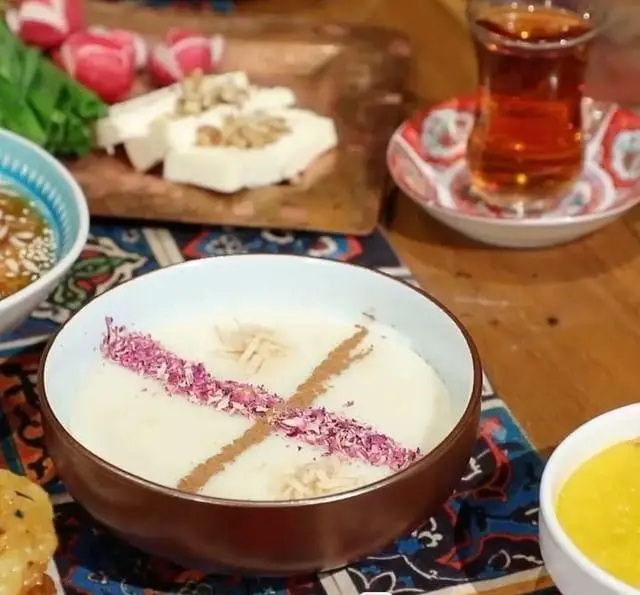 سفره صبحانه سنتی و خوشمزه در کافه رستوران قصر ایرانیان شامل شیربرنج، پنیر و گردو، سبزیجات تازه، چای و خوراکی‌های اصیل ایرانی