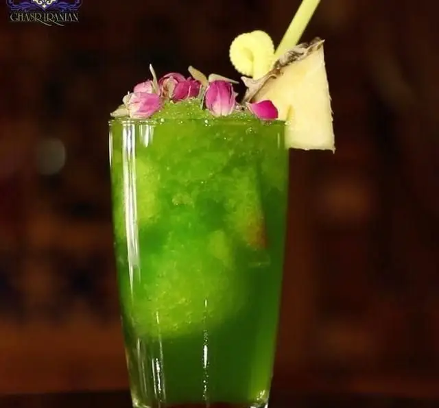 نوشیدنی خنک و سبز رنگ قصر ایرانیان، تزئین شده با گلبرگ‌های گل محمدی و آناناس، تجربه‌ای دلچسب در کافه رستوران سنتی