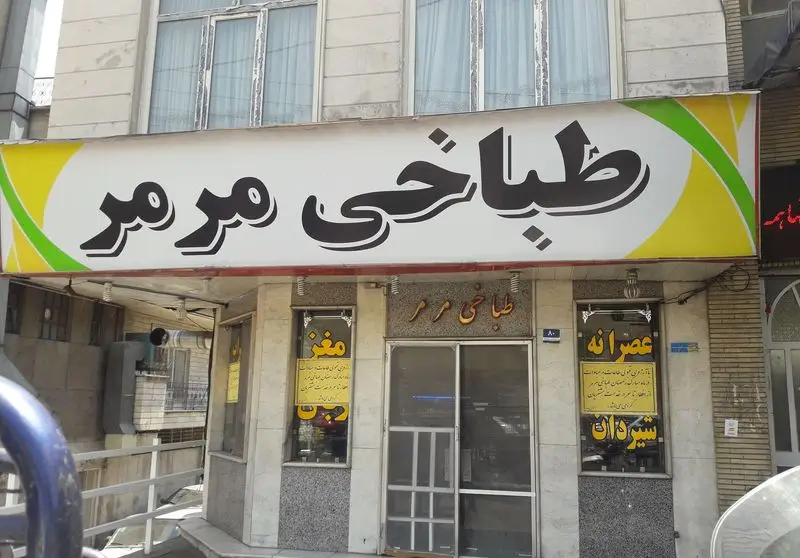 تصویر نمای بیرونی طباخی مرمر با تابلوی بزرگ و روشن آن که نام کسب و کار را نشان می‌دهد و منوی مغز، عصرانه، شیردان در ویترین.