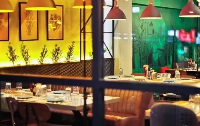 فضای داخلی دنج و مدرن فست فود روکو، با میزهای چیده شده و دکوراسیون زیبا، آماده استقبال از مشتریان برای تجربه غذایی لذت‌بخش.