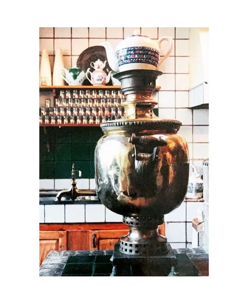 سماور برنجی بزرگ و قوری روی آن، نمادی از سنت و مهمان‌نوازی در رستوران ایرانی آذری، آماده پذیرایی از میهمانان با چای.