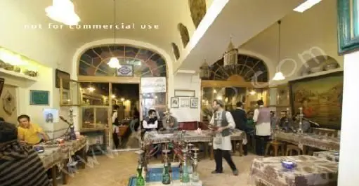 فضای داخلی زیبای رستوران سنتی و قلیان‌سرای ایرانی آذری با دکوراسیون خاص و مشتریان در حال لذت بردن از غذا و قلیان.