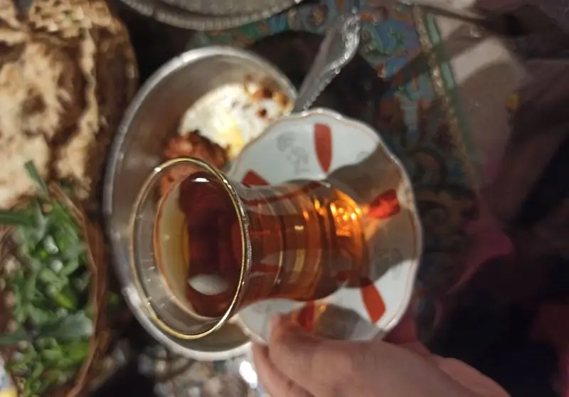 چای سنتی ایرانی-آذری سرو شده در کنار صبحانه کامل با نان، سبزی و غذای محلی در محیط دلنشین رستوران.