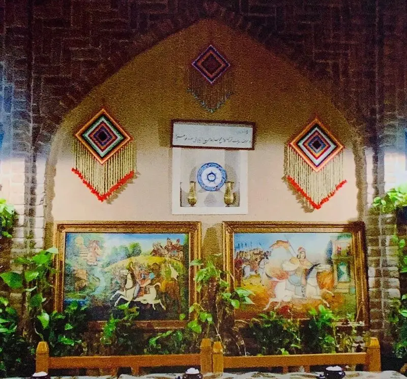 دکوراسیون داخلی رستوران سنتی ایرانی آذری با نقاشی‌های اساطیری و صنایع دستی زیبا، فضایی دلنشین برای صرف غذای اصیل ایرانی.