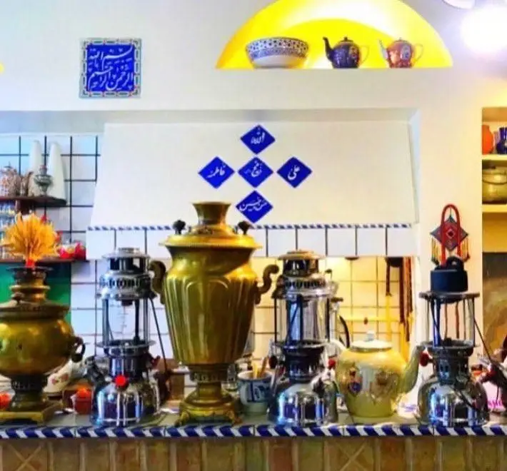 نمای داخلی رستوران سنتی ایرانی آذری با مجموعه ای از سماورها و فانوس های قدیمی، فضای دلنشین و چایخانه ای اصیل را به تصویر می کشد.
