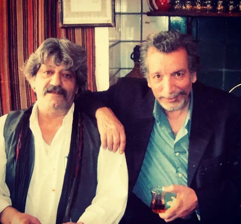 دو مرد در فضایی سنتی رستوران ایرانی آذری، لحظاتی دلنشین با چای گرم و محیطی صمیمی برای تجربه غذای اصیل.