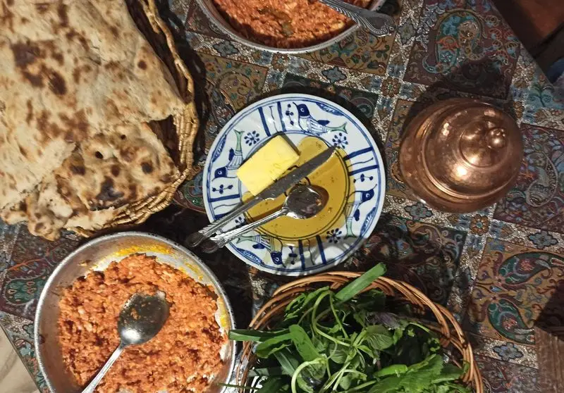 سفره رنگارنگ صبحانه سنتی و دلنشین ایرانی آذری: نان داغ، خوراک یا املت، کره و عسل، سبزی تازه. تجربه‌ای اصیل در رستوران
