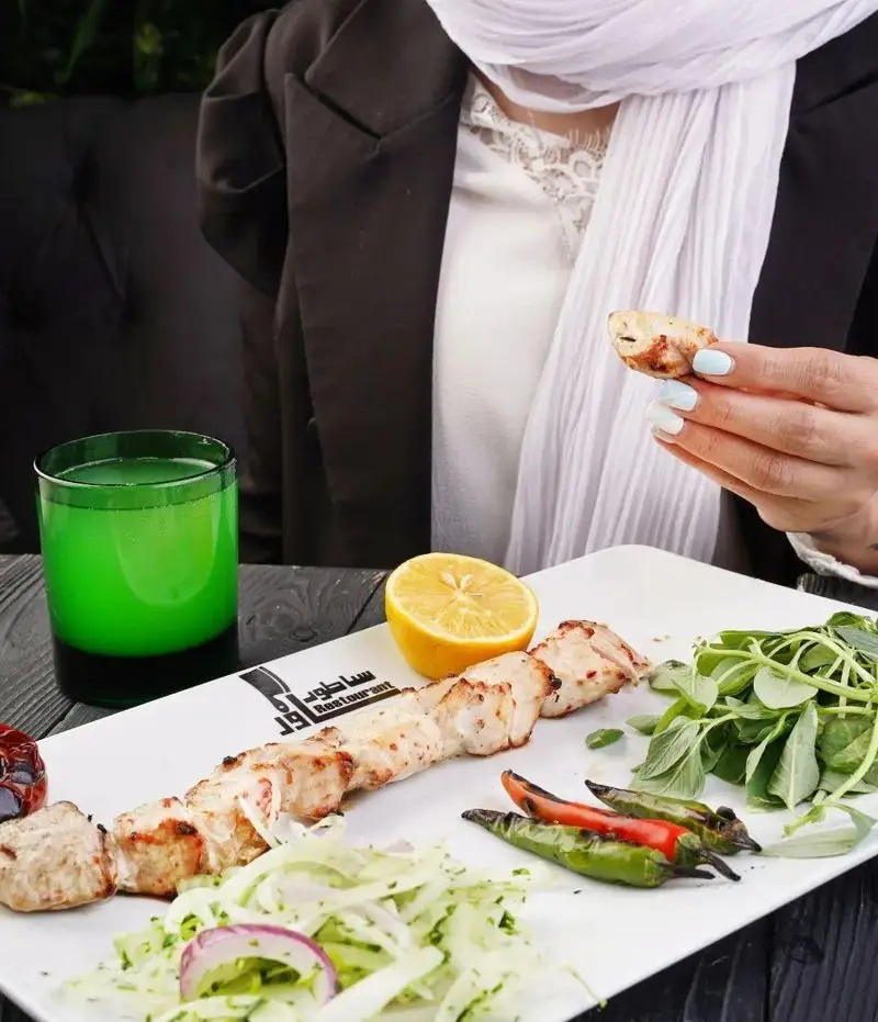 لذت تجربه جوجه کباب اصیل ایرانی در رستوران ساطور. طعم بی‌نظیر کباب با نوشیدنی خنک و سبزی تازه، بهترین انتخاب برای ناهار یا شام.