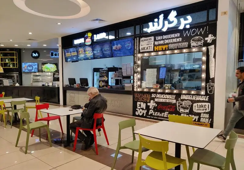 نمای داخلی فست فود برگر لند، یک رستوران مدرن با منوی دیجیتال برگر و ساندویچ‌های متنوع، فضای غذاخوری و پیشخوان سفارش.