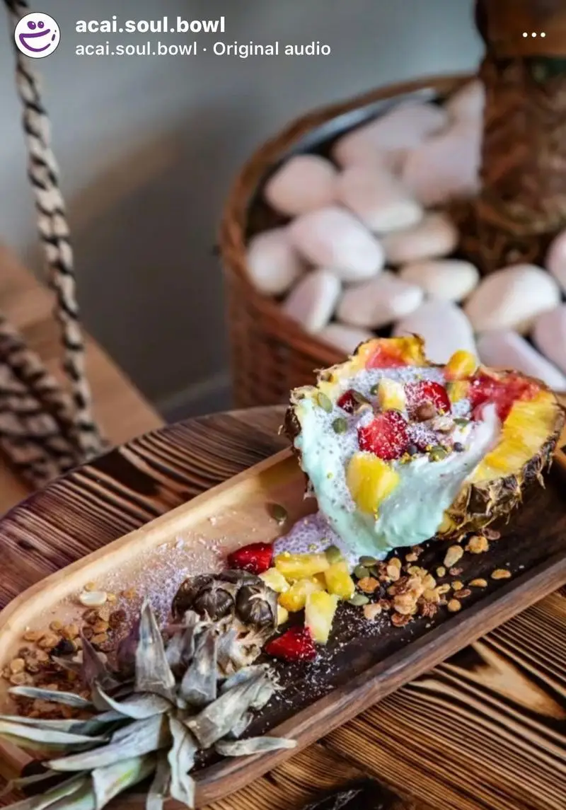 اسموتی کاسه آسایی تازه و رنگارنگ در نیمه آناناس طبیعی، تزئین شده با میوه‌های بریده شده، گرانولا و دانه چیا. یک صبحانه سالم از آسایی کاسه روح.