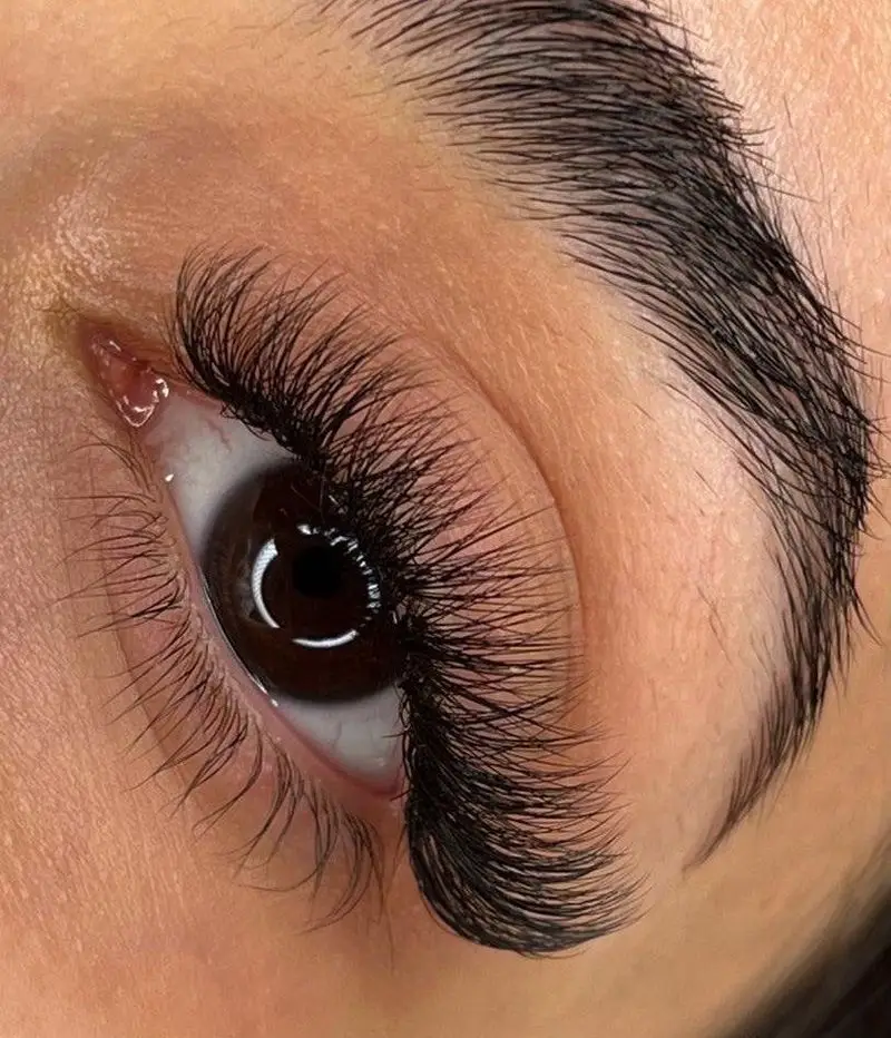 نمای نزدیک از چشم با اکستنشن مژه والیوم مشکی پرپشت و ابروی مرتب، خدمات حرفه‌ای زیبایی مژه و ابرو در آسایی کاسه روح.