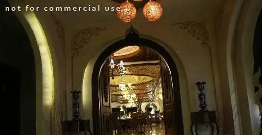 فضای داخلی مجلل و سنتی رستوران شهرزاد با ورودی طاق‌دار، لوسترهای آویز و نمای سالن غذاخوری باشکوه.