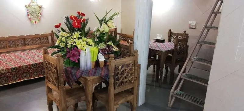 فضای دلنشین رستوران جگرسرای راک با تخت سنتی، میز و صندلی چوبی، دکوراسیون زیبا و دسته گل بزرگ برای تجربه غذایی لذت‌بخش.