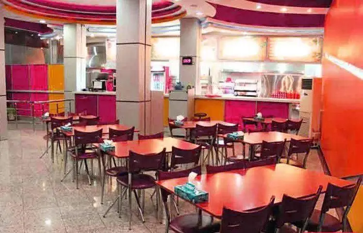 سالن غذاخوری جذاب پیتزا ونوس با دکوراسیون رنگارنگ، میز و صندلی‌های مدرن، فضایی دلنشین و شیک برای تجربه غذایی لذت‌بخش.