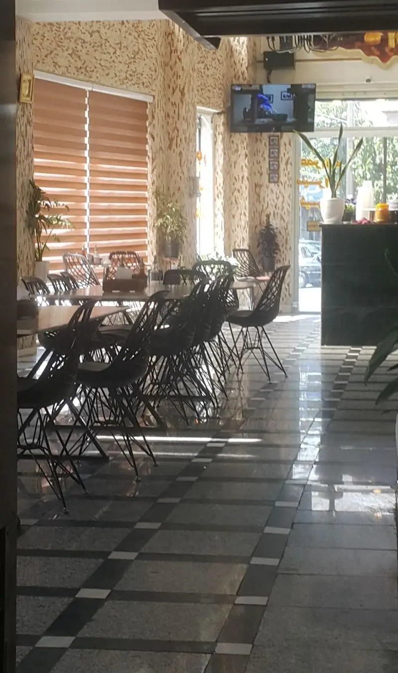 فضای داخلی تمیز و دلباز طباخی طهران با میز و صندلی‌های شیک، کفپوش طرح‌دار و پنجره‌های بزرگ نورگیر، مناسب برای مشتریان.