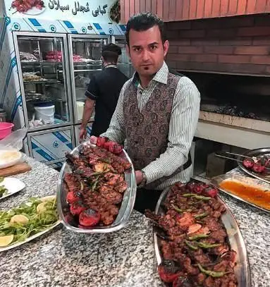 کباب مجلل ساوالان: سرآشپشز دو سینی بزرگ کباب کوبیده، چنجه و جوجه کباب را برای مشتریان آماده می‌کند.