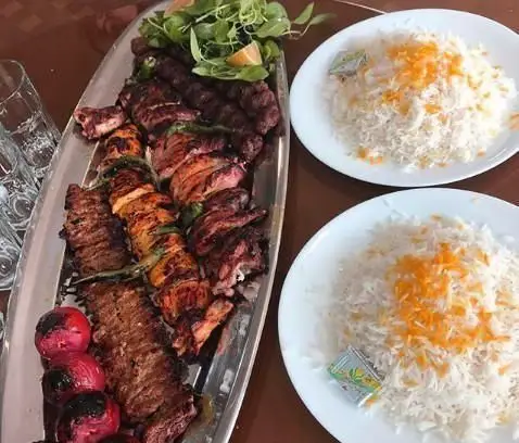 سینی بزرگ کباب مجلل ساوالان شامل کباب کوبیده، جوجه کباب، چنجه، و گوجه کبابی با دو بشقاب برنج زعفرانی؛ غذای ایرانی لذیذ.