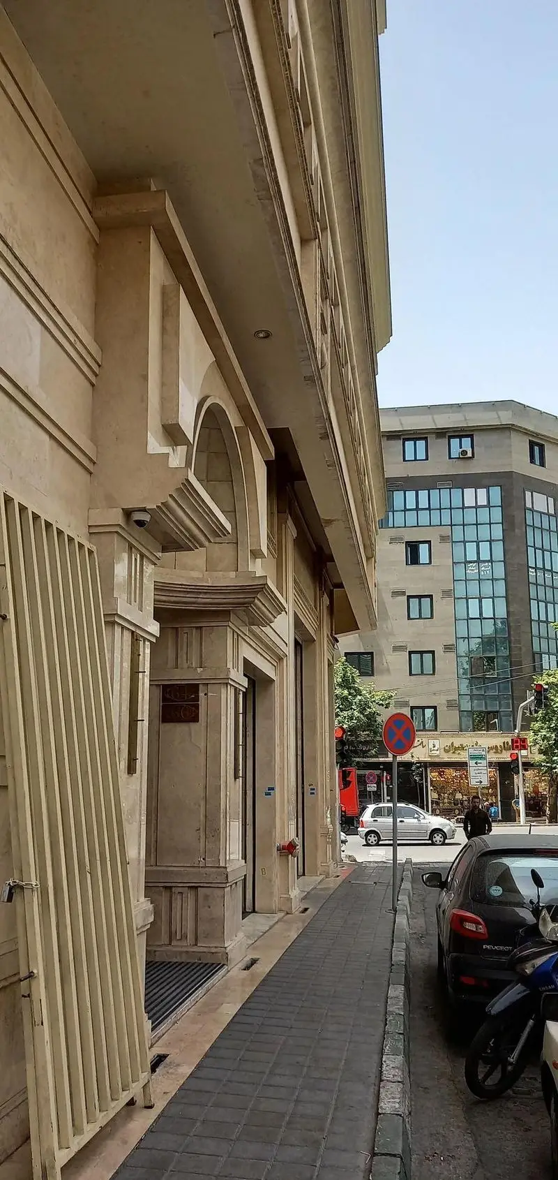 نمای بیرونی رستوران ماهان شاندیز شریعتی در خیابان شلوغ، با ورودی شیک و نمای سنگی زیبا، نشان‌دهنده دسترسی آسان و محیط دلنشین.