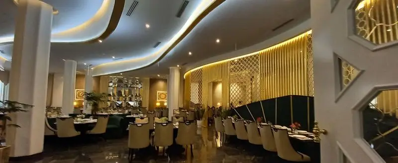 فضای داخلی لوکس و مدرن رستوران ماهان شاندیز شریعتی با نورپردازی زیبا و دکوراسیون طلایی، محیطی شیک برای غذاخوری.