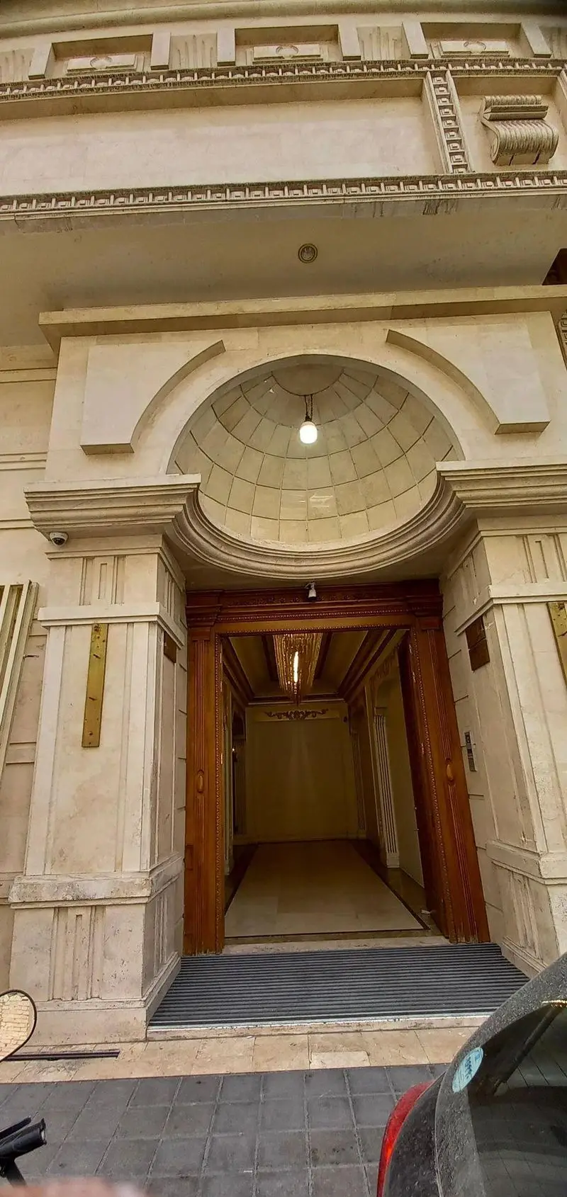 ورودی مجلل و باشکوه رستوران ماهان شاندیز شریعتی با معماری کلاسیک، درب‌های چوبی کنده‌کاری شده و سردر گنبدی زیبا.