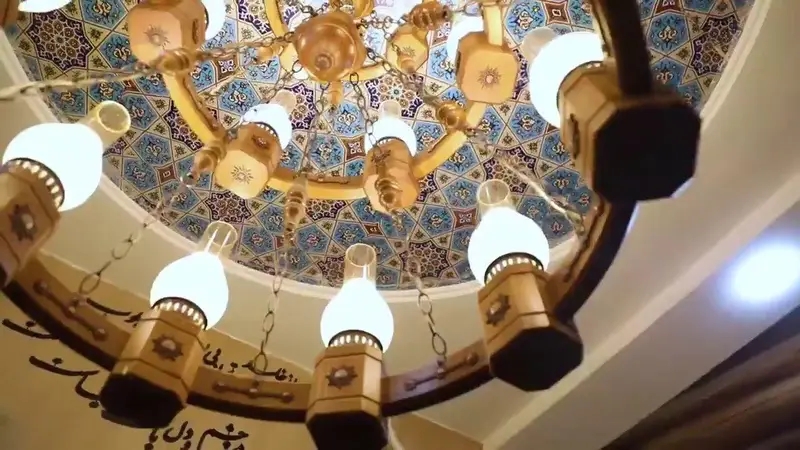 کافه رستوران سنتی خشت بهشت: لوستر زیبای سنتی و سقف گنبدی کاشی‌کاری با نقوش ایرانی، نشانگر دکوراسیون دلنشین و اصیل این مکان.