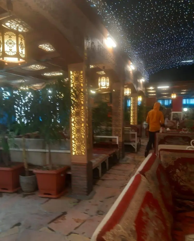 فضای دلنشین و سنتی باغچه‌ خانوادگی آبشار با سقف پرستاره، فانوس‌های زیبا و نورپردازی گرم در شب، محیطی آرامبخش برای خانواده.