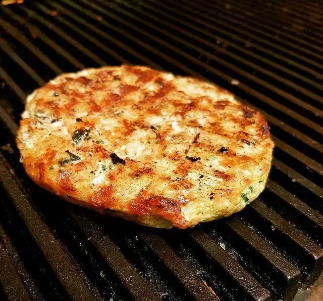 پتی خوشرنگ و خوش‌طعم فست فود برگریچ در حال گریل شدن روی شعله، آماده سرو یک برگر کبابی لذیذ و داغ.