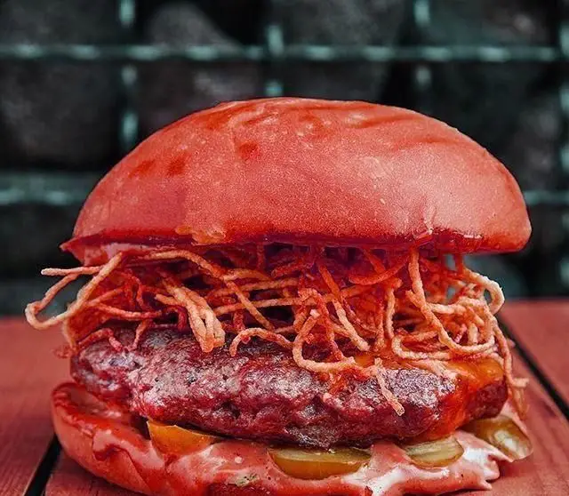 همبرگر ویژه و خوشمزه پلاتین فود گاردن با نان قرمز جذاب، پیاز سوخاری ترد و سس‌های خاص. تجربه‌ای لذیذ در رستوران.