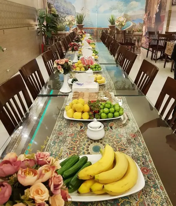 چیدمان شیک میز در رستوران فاخر با انواع میوه‌های فصلی تازه و دکوراسیون مجلل، ایده‌آل برای بوفه پذیرایی یا ضیافت‌های بزرگ.