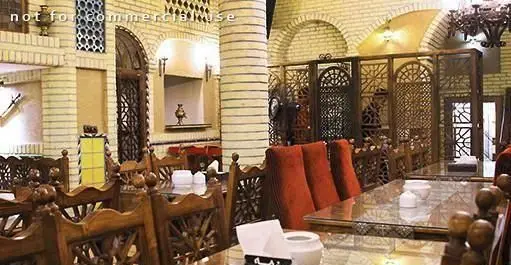 دکوراسیون داخلی سفره خانه سنتی سماع: فضایی گرم و دلنشین با دیوارهای آجری، طاق‌های سنتی و میز و صندلی‌های چوبی با پشتی‌های قرمز.