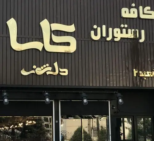 نمای بیرونی کافه رستوران کاسا دل شف: تابلوی طلایی رنگ با نام "کاسا دل شف" و "کافه رستوران" روی زمینه تیره و خط‌دار.