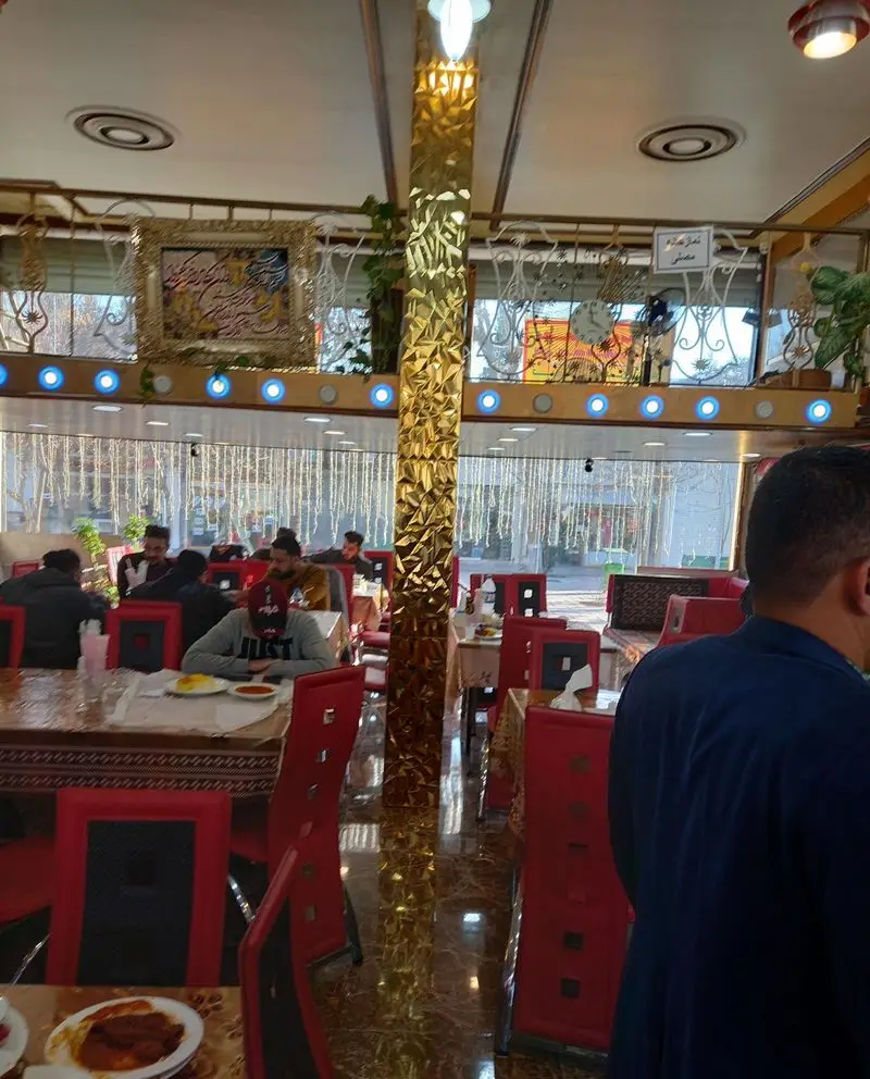 رستوران موسوی: محیطی گرم و دلنشین با میزهای چوبی و صندلی‌های قرمز برای لذت بردن از انواع غذاهای اصیل ایرانی و محلی.