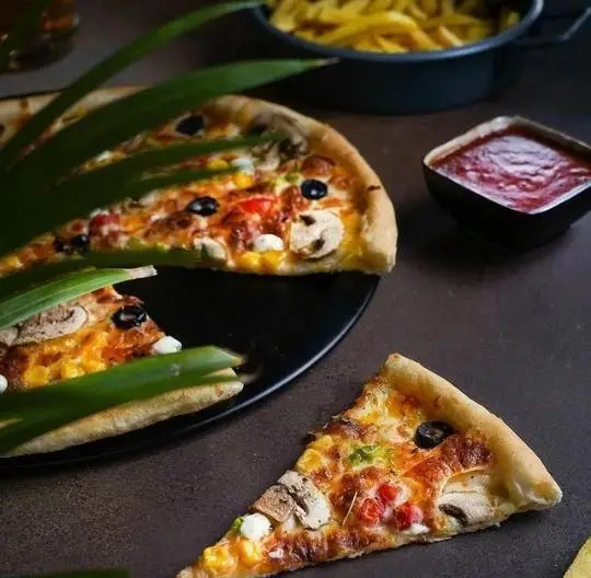 پیتزا قارچ و زیتون خوشمزه سیب ۳۶۰ همراه با سیب زمینی سرخ کرده و سس گوجه، یک وعده غذایی لذیذ و پرطرفدار فست فود.