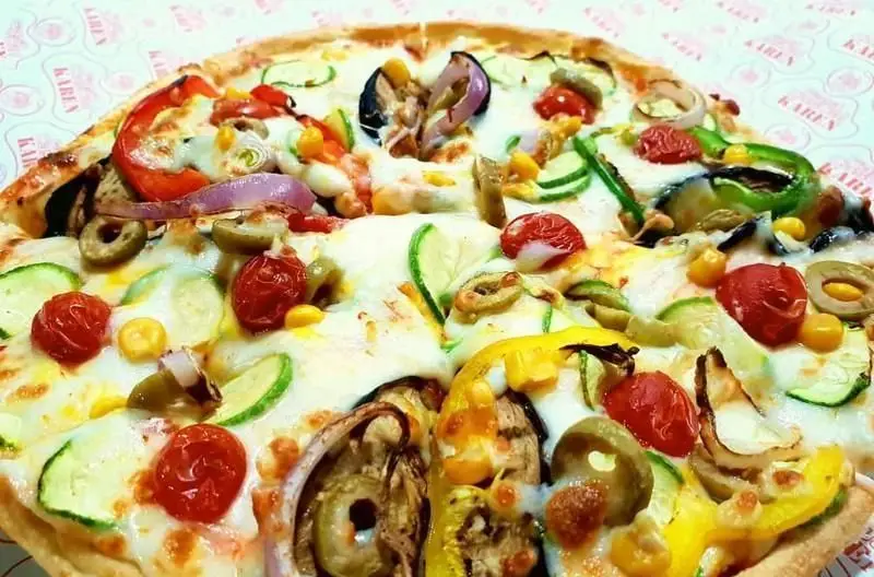 پیتزای سبزیجات پرملات و خوشمزه فست فود نامیا با پنیر، گوجه گیلاسی، زیتون، کدو، بادمجان، ذرت، پیاز و فلفل دلمه‌ای تازه.