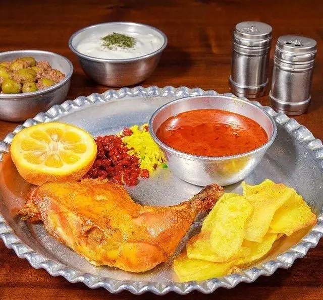 غذای چلو مرغ رستوران ایرانی برادران حاجی عباسی شامل ران مرغ برشته، زرشک پلو، ته دیگ، ماست و زیتون پرورده.