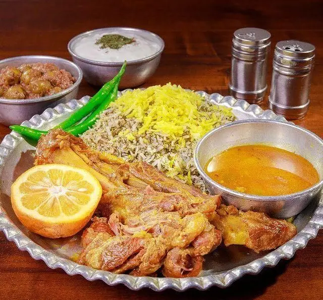 چلو گوشت لذیذ رستوران ایرانی برادران حاجی عباسی با برنج پلوی زعفرانی و مخلفات کامل، تجربه‌ای اصیل از غذای سنتی.