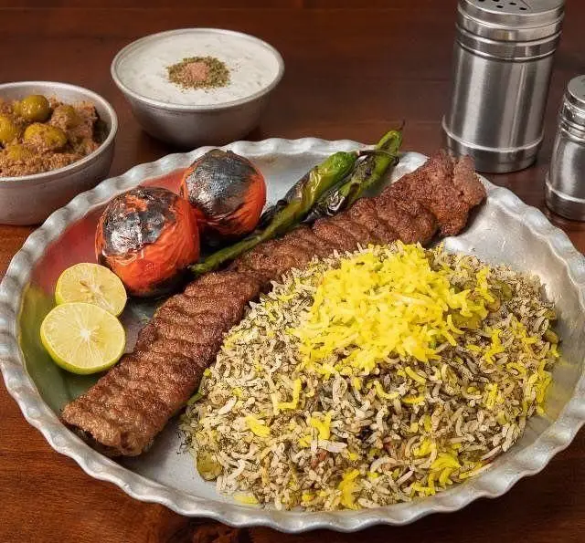 کباب کوبیده، شوید پلو با ته دیگ زعفرانی و مخلفات خوشمزه در رستوران ایرانی برادران حاجی عباسی. غذای سنتی و دلپذیر ایرانی.