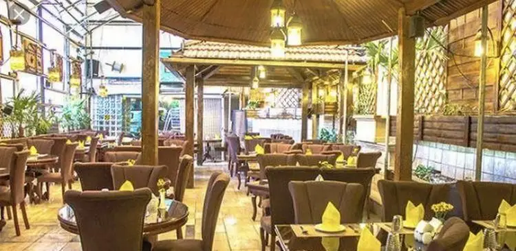 فضای دلنشین و سرسبز رستوران باغ گیلاس، ایده‌آل برای صرف غذا و دورهمی. دکوراسیون چوبی زیبا و نورپردازی گرم، محیطی آرامش‌بخش را فراهم کرده است.