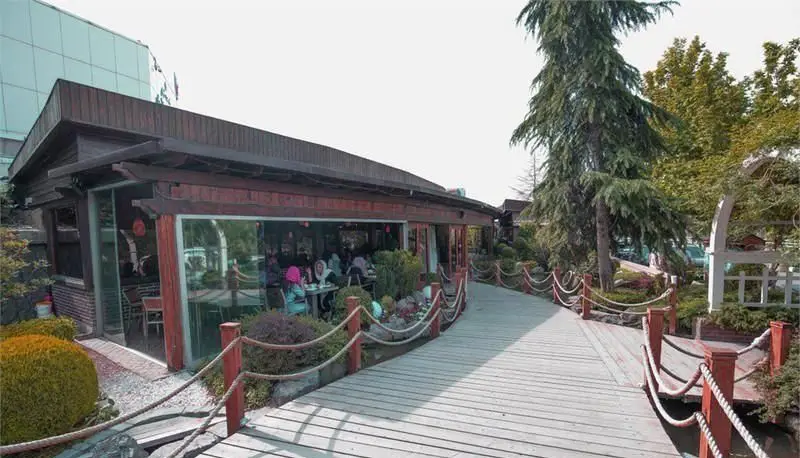 رستوران ترکیه ای دنر تُرد با فضای باز زیبا، پیاده‌رو چوبی و محیطی دلنشین برای سرو دنر لذیذ و غذاهای ترکی.