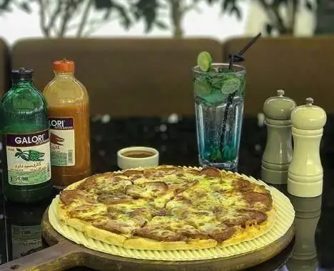 پیتزای خوشمزه کافه ایزار به همراه سس‌های گالوری و نوشیدنی خنک در محیط دلنشین کافی شاپ ایزار، انتخابی عالی برای لذت بردن از غذا.