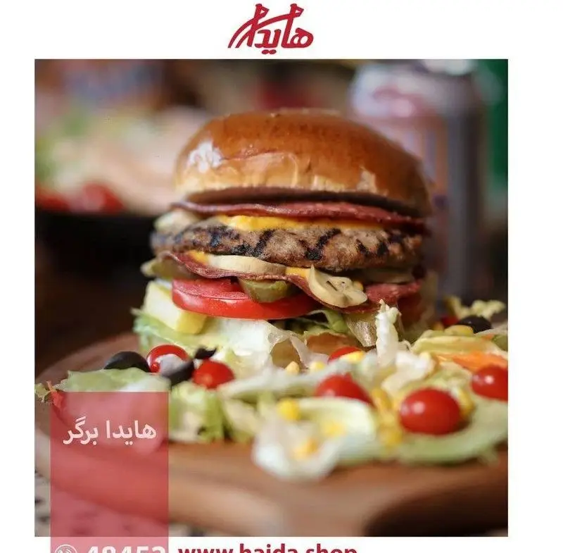 هایدا برگر با گوشت طعم‌دار گریل شده، لایه‌های پنیر و بیکن، خیارشور، گوجه‌فرنگی و سالاد ساید تازه در فست فود هایدا.