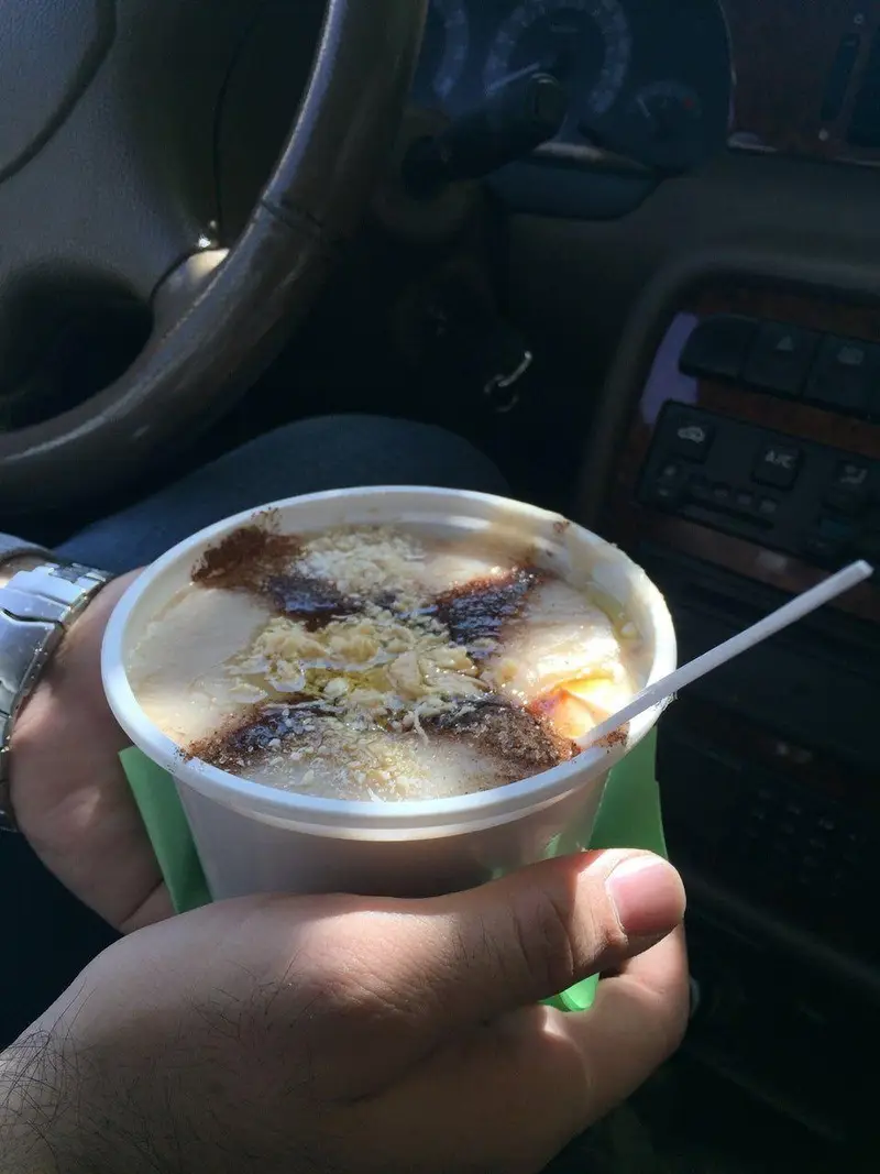 لذت خوردن حلیم سنتی و خوشمزه ناصر در فنجان بیرون‌بر در داخل خودرو، صبحانه‌ای مقوی و پرانرژی برای شروع روز.