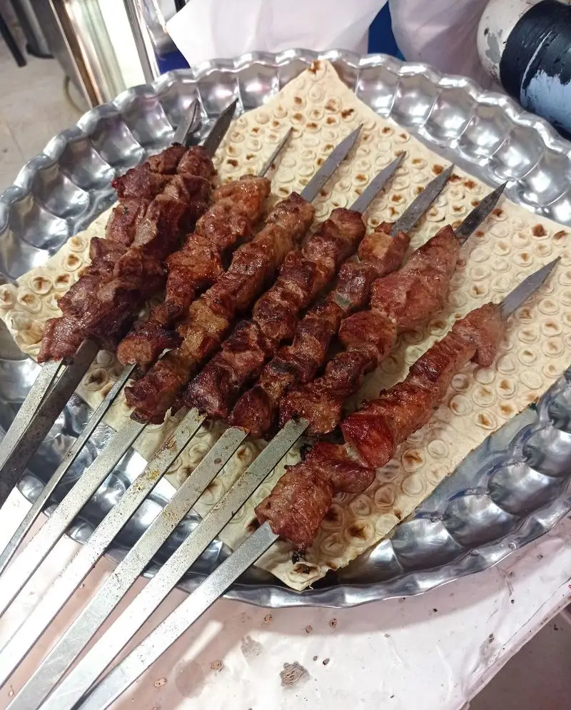 جگرکی لوکس طلائی: کباب جگر تازه و لذیذ روی نان داغ، آماده سرو در سینی فلزی شیک. تجربه طعمی بی‌نظیر از غذای ایرانی اصیل.