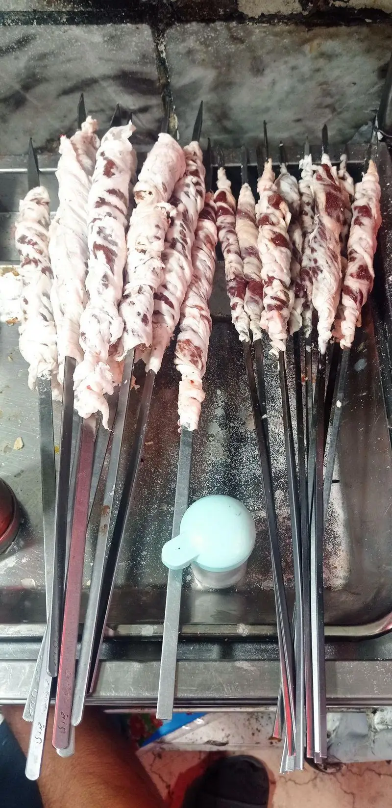 سیخ های لذیذ جگر و چربی تازه آماده پخت، ارائه شده با بالاترین کیفیت در جگرکی لوکس طلائی. یک تجربه غذایی بی‌نظیر.