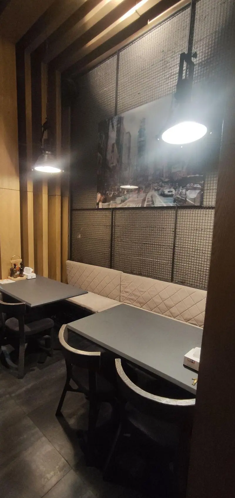 فضای داخلی شیک و مدرن رستوران ای تی اف شعبه کاشانی، با میز و نیمکت‌های راحت، نورپردازی جذاب و دکوراسیون دیواری منحصر به فرد.