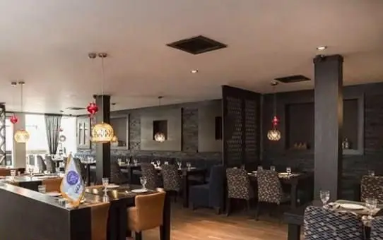 فضای داخلی شیک و مدرن رستوران توتیا با میز و صندلی‌های چیدمان شده، دکوراسیون خاص و نورپردازی زیبا برای تجربه غذایی دلنشین.