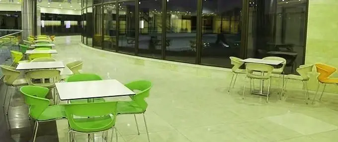 فضای داخلی رستوران ایرانی فرندز اکسپرس با میز و صندلی‌های سبز مدرن و چیدمان منظم، آماده پذیرایی از مشتریان.