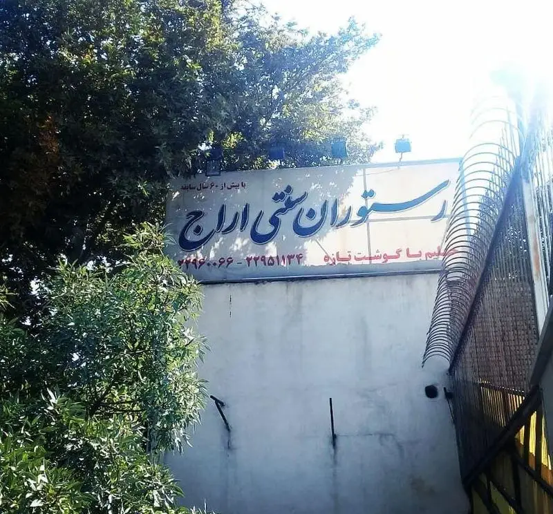 تابلوی بزرگ و قدیمی رستوران سنتی اراج با بیش از شصت سال سابقه درخشان در تهیه غذا با گوشت تازه، همراه با شماره تلفن‌ها.