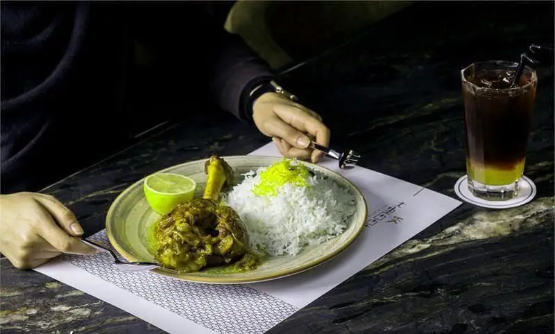 چلو مرغ مجلسی و نوشیدنی خنک در کافه رستوران کالوک، تجربه‌ای دلپذیر از غذای ایرانی با سس خوش طعم و برنج زعفرانی.