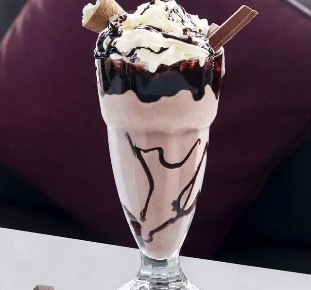 میلکشیک شکلاتی خوشمزه کافه رستوران کالوک با خامه، سس شکلات و تزیینات ویژه، انتخابی عالی برای دوستداران دسر و نوشیدنی‌های خنک.